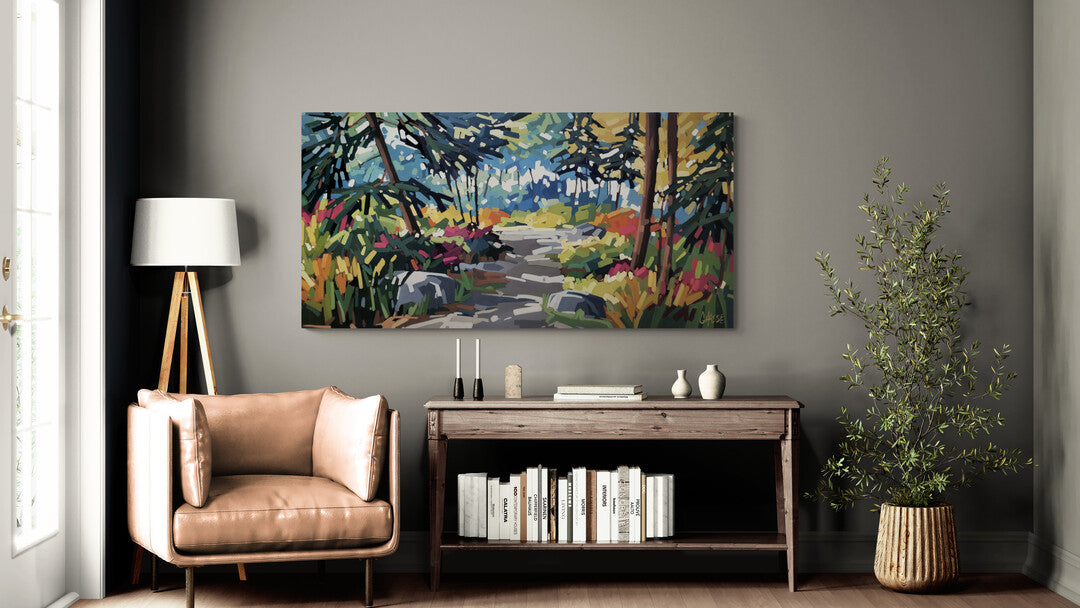 Mise en situation du tableau « Le moment où la forêt m'a parlé » de Martine Chassé, accroché dans un salon épuré aux murs gris-vert, au-dessus d'une console en bois rustique. Un fauteuil en cuir caramel et une plante verte complètent l'ambiance chaleureuse et naturelle de la pièce.